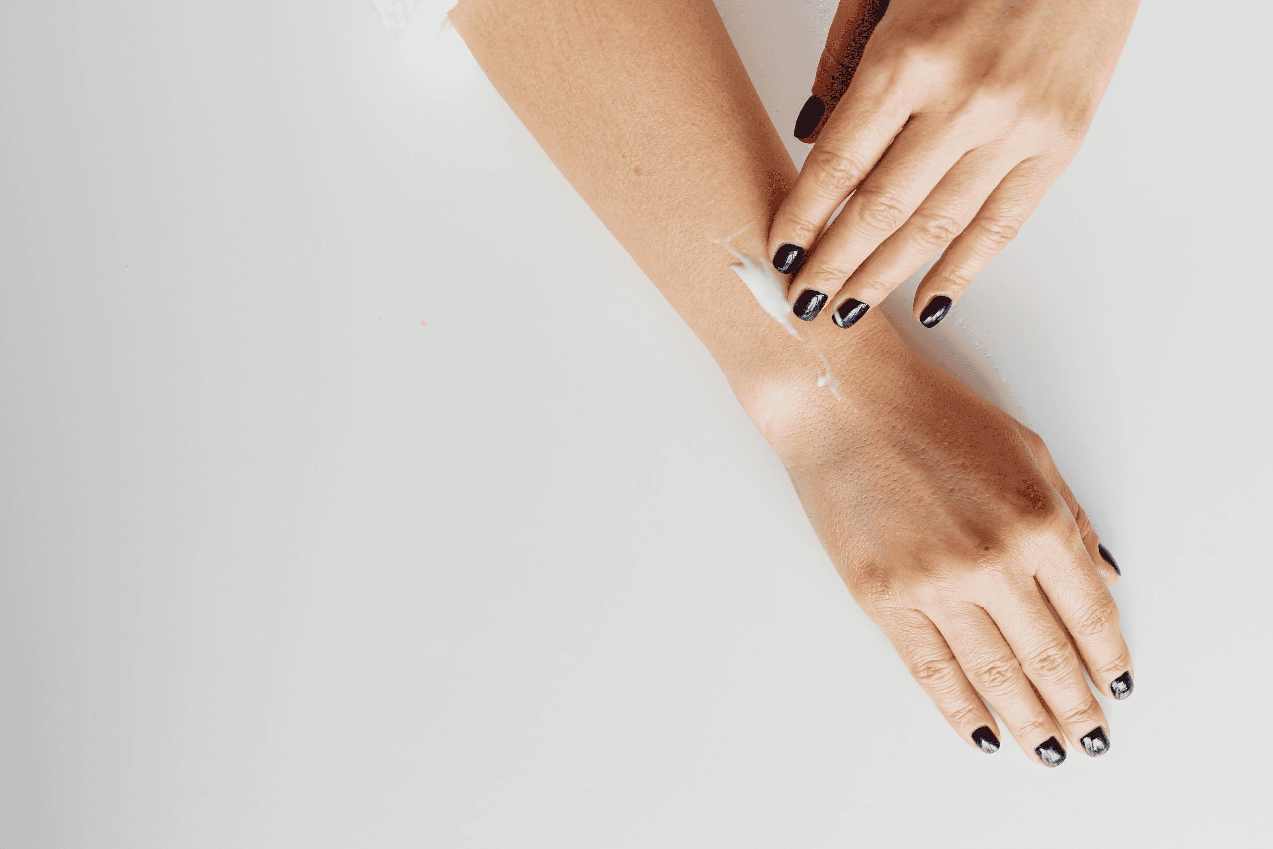 woman applying hand cream on her arm