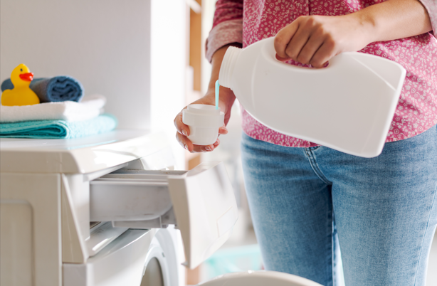 woman putting liquid powder to clean the clothes.