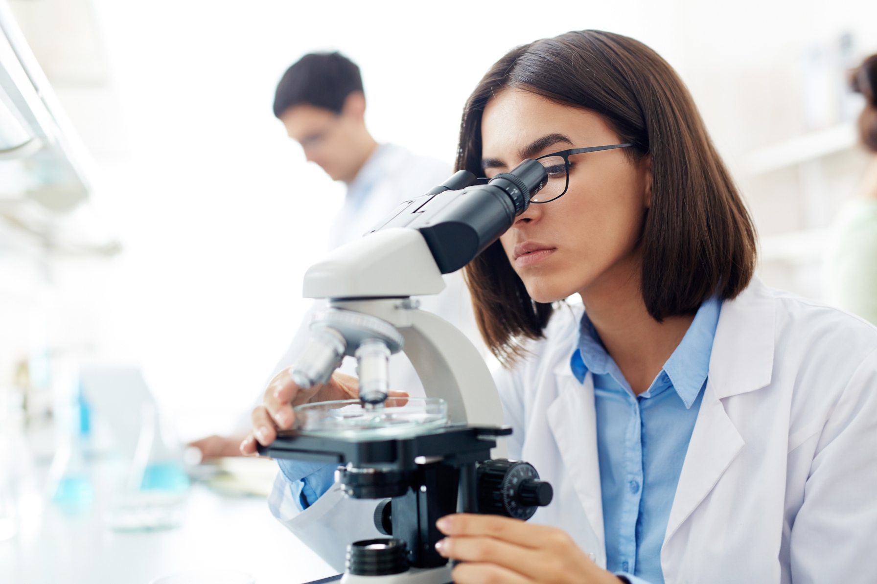 Lab technician trying to see through a microscope