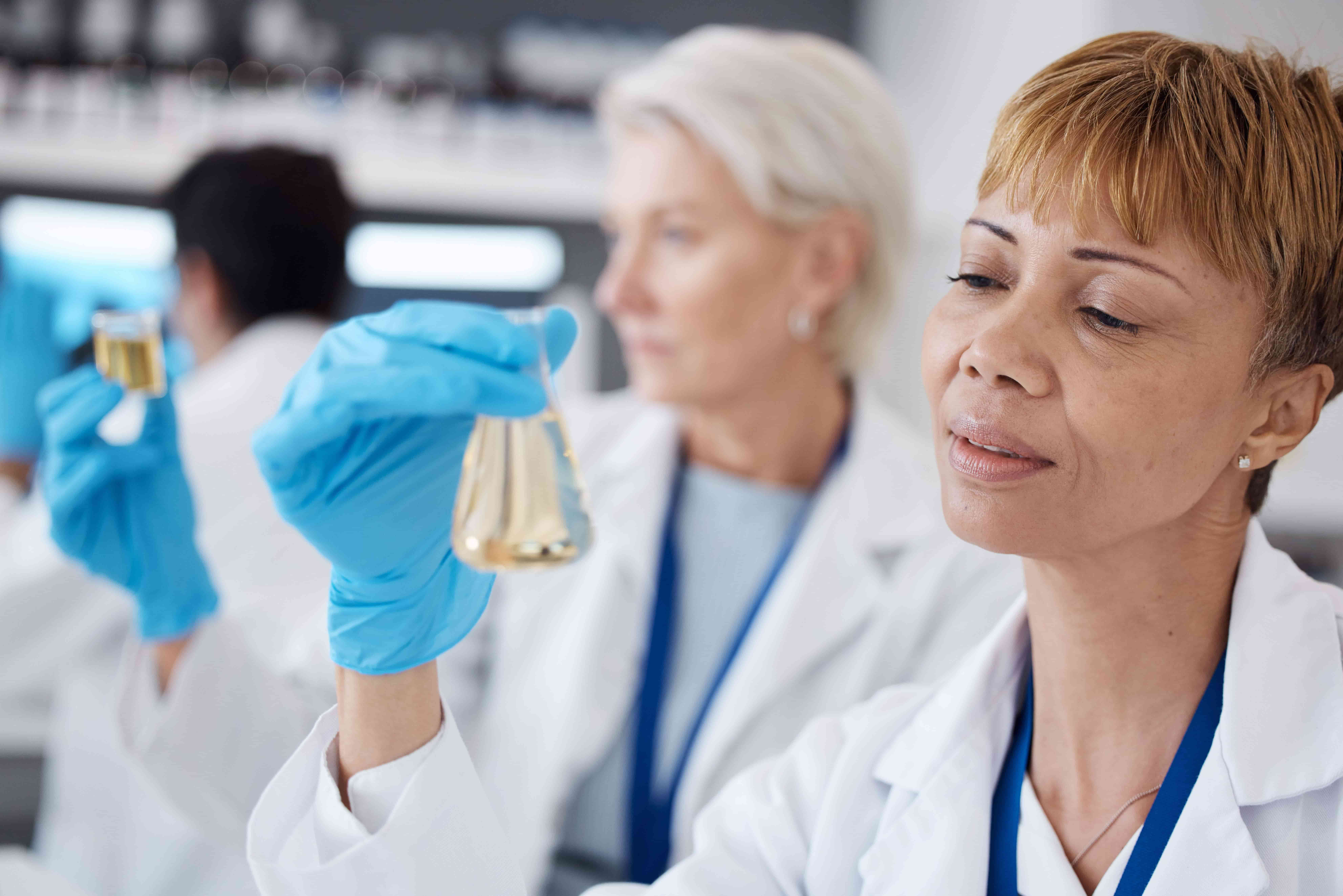 Pesquisadora em laboratório cosmético analisando formulações para desenvolvimento de produtos seguros e conformes à regulamentação.