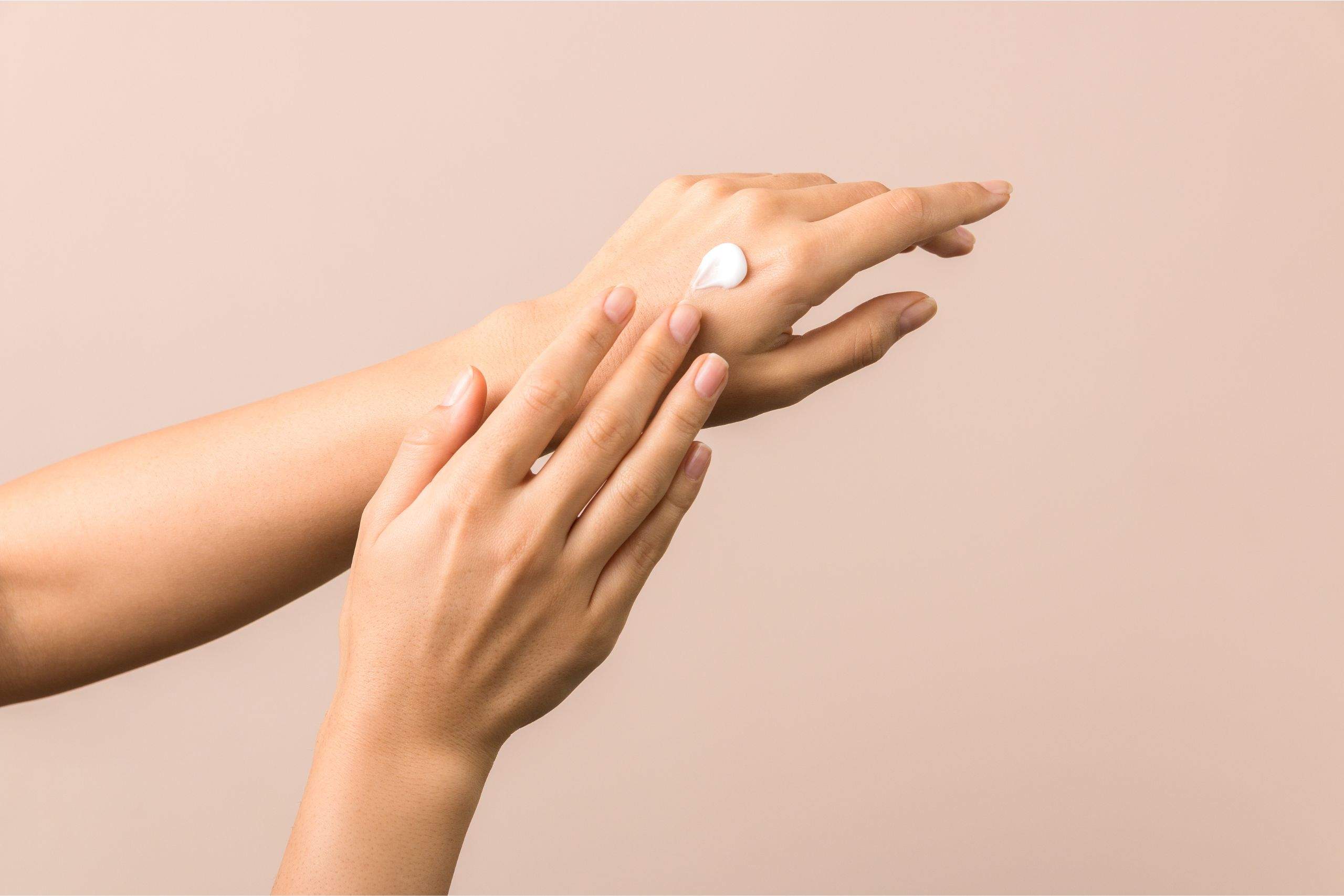 woman hand applying hand cream on her other hand