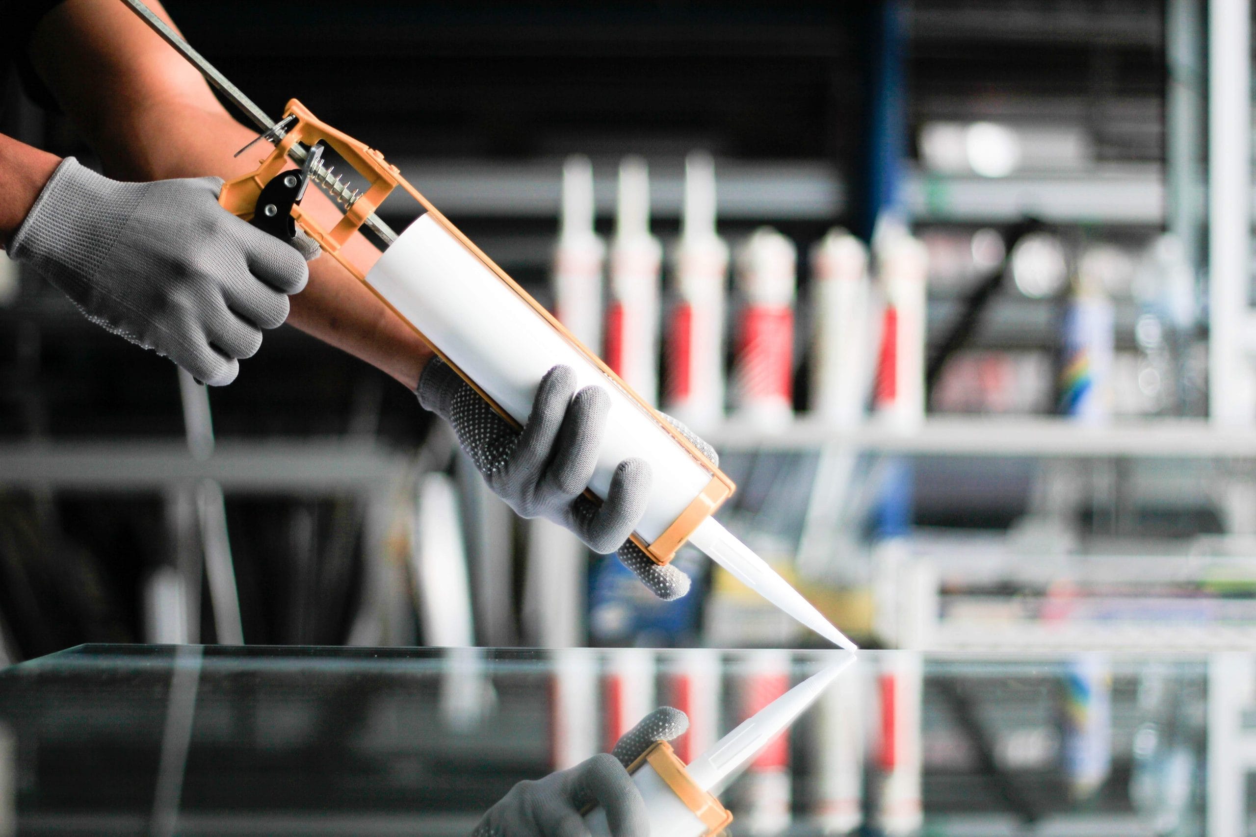 Men's hand uses silicone adhesive with adhesive to connect the mirror with aluminum.