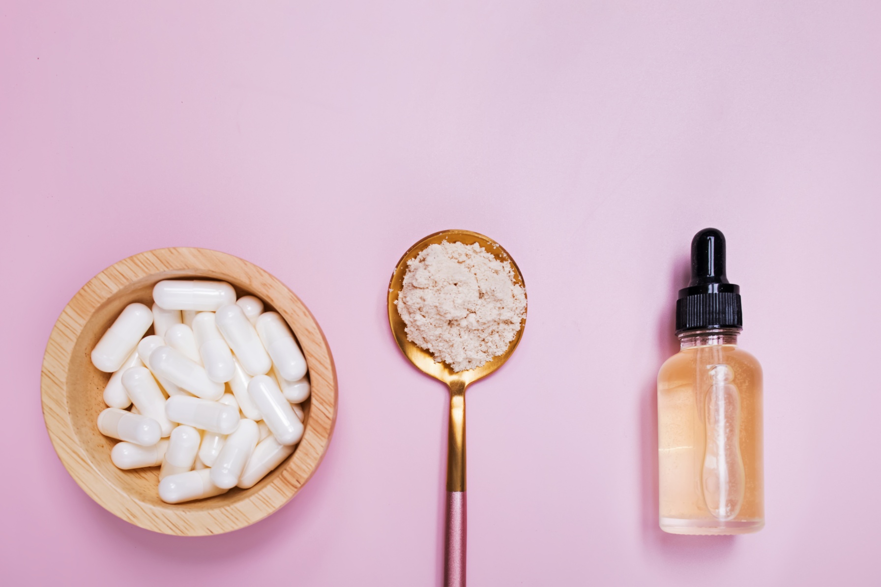 Collagen Serum, Powder and Pills on Pink Background