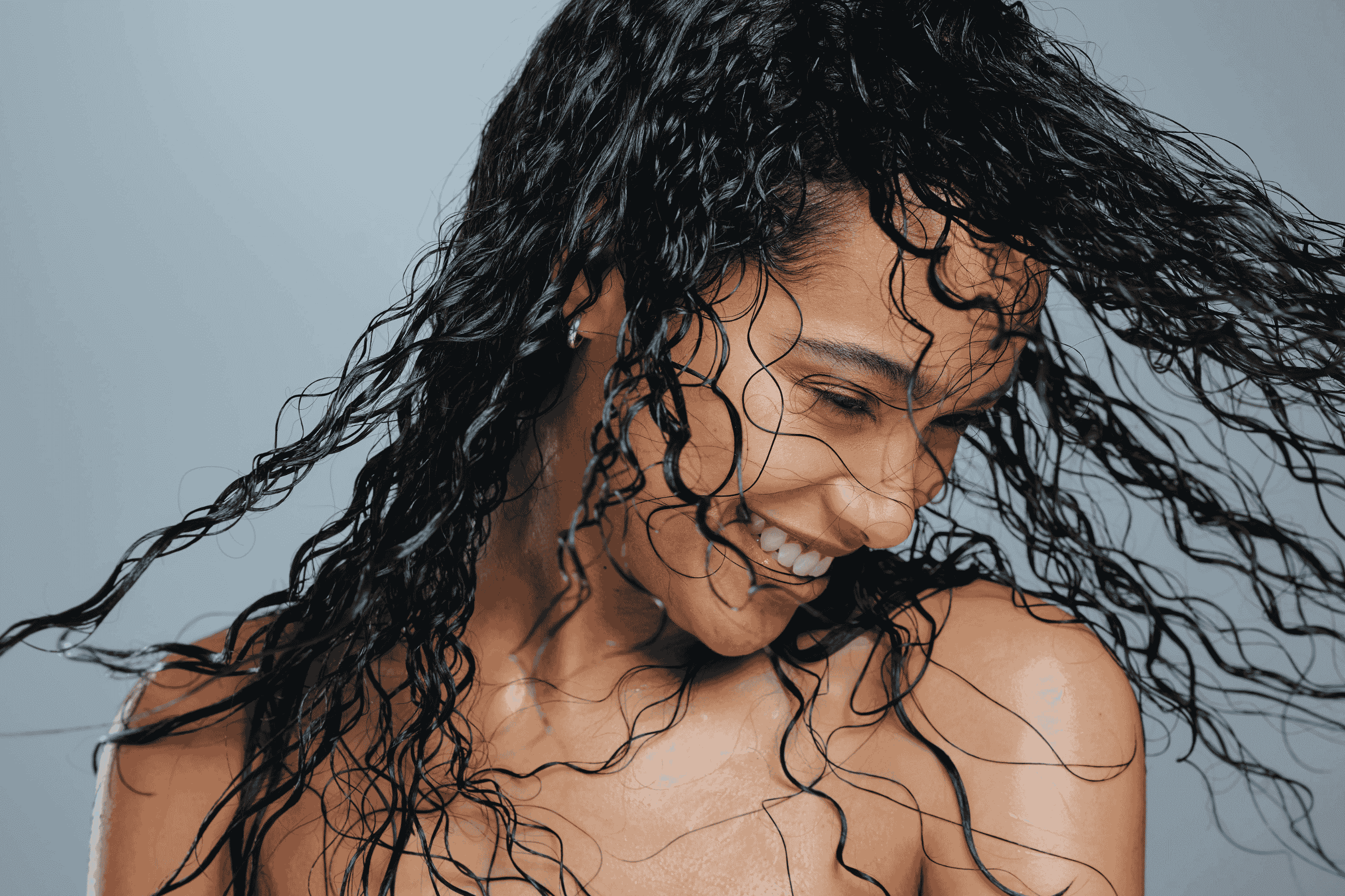 happy woman with beautiful hair because of cuidado capilar