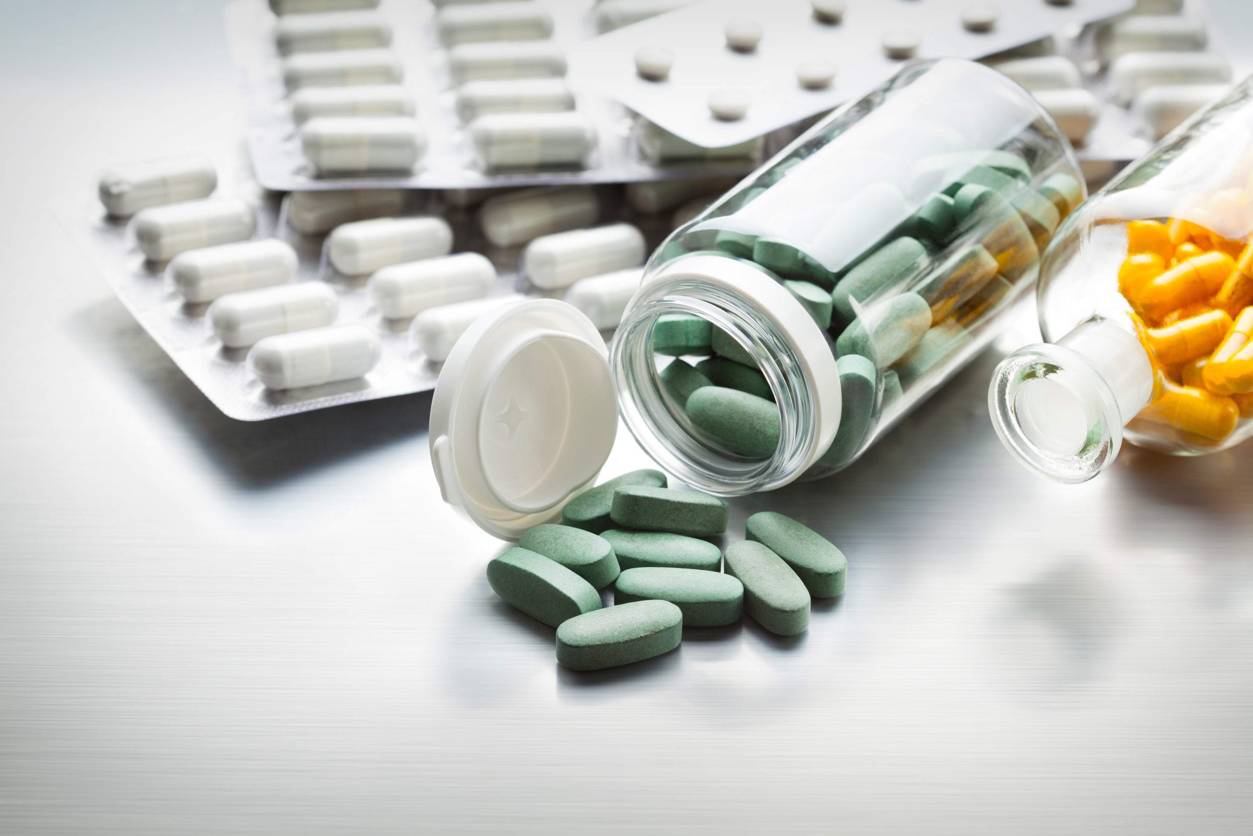 Different medicines on a gray metal table as a symbol of the pharmaceutical industry