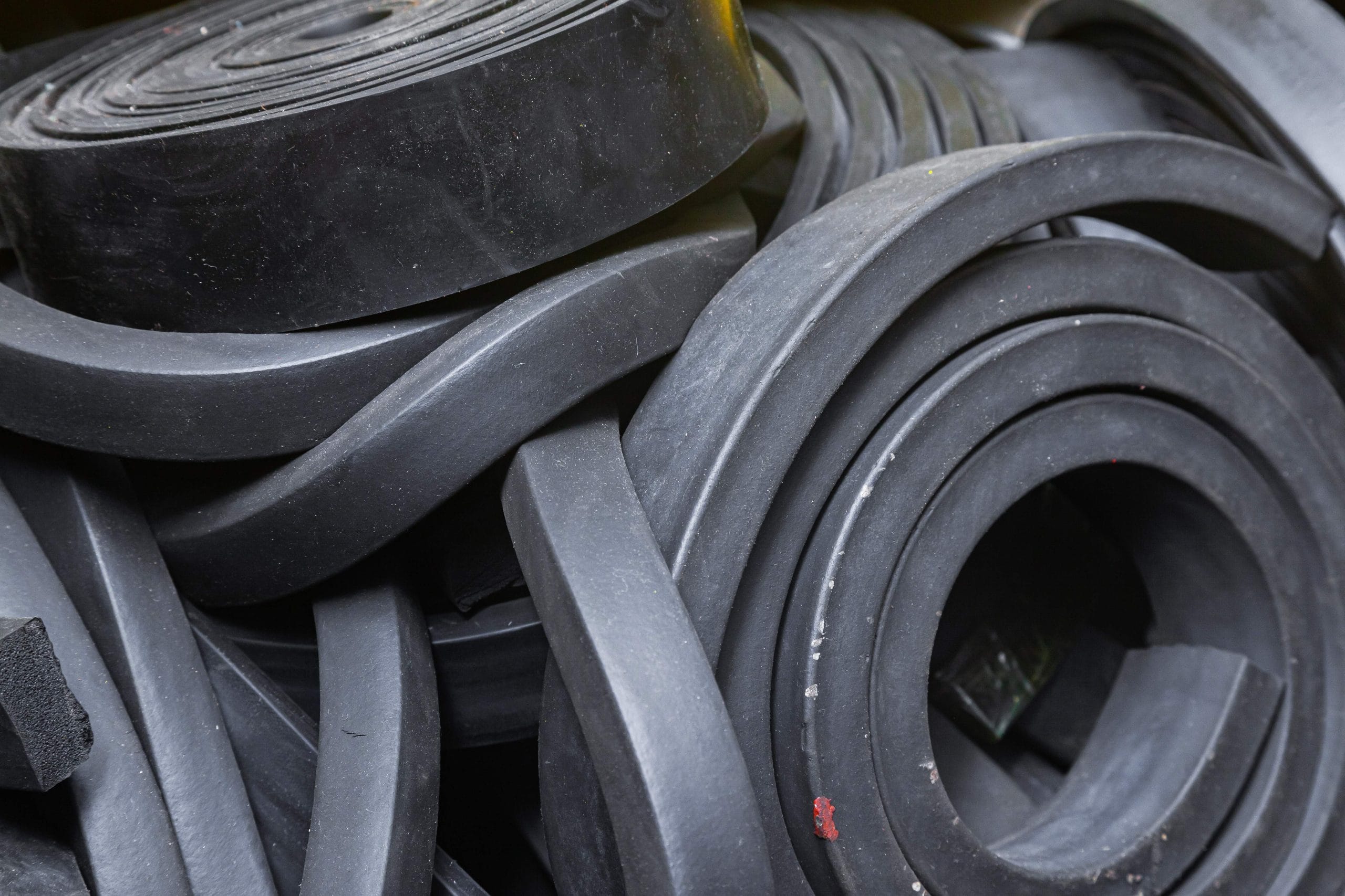 Close-up rubber sealing strips for waterproof doors. A pile of rubber twisted into rolls.