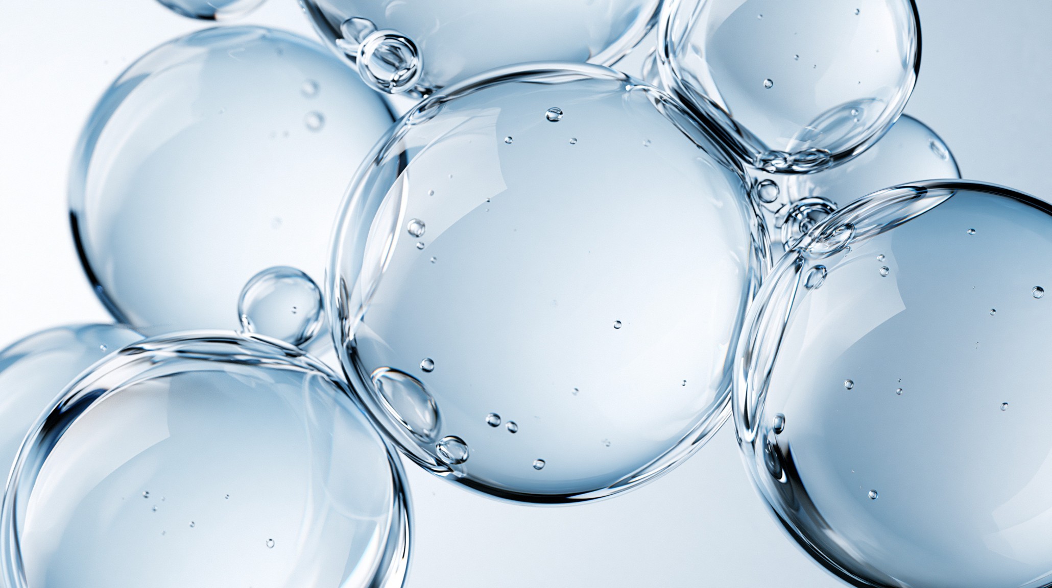 Close-up of numerous bubbles of clear, translucent liquid with shiny, reflective surfaces, representing hyaluronic acid.